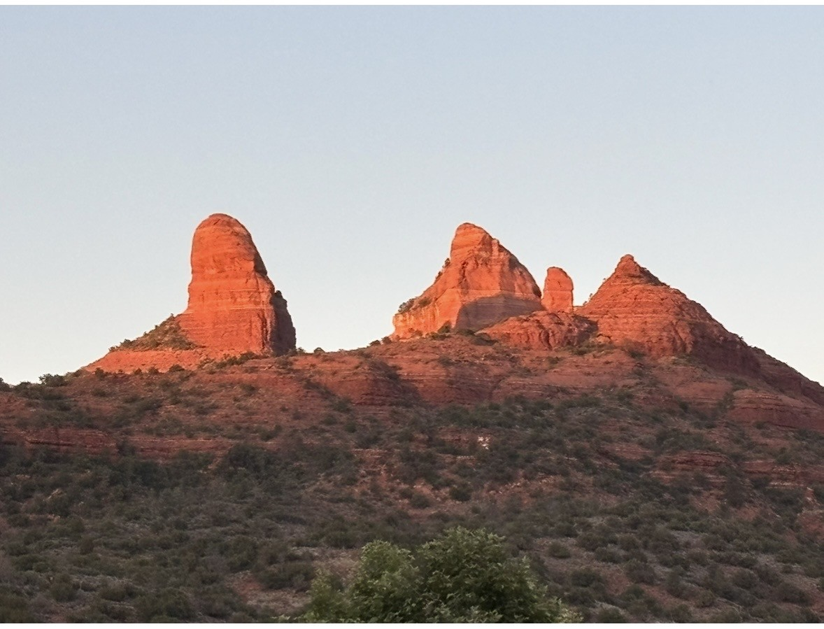 Sedona red rock formations glowing at sunset against a soft sky