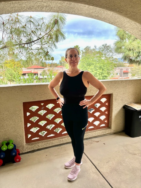 Linda in 2024 standing confidently on a sunlit patio in athletic wear