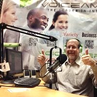 Naftali Schwartz in the VoiceAmerica studio giving two thumbs up at the microphone