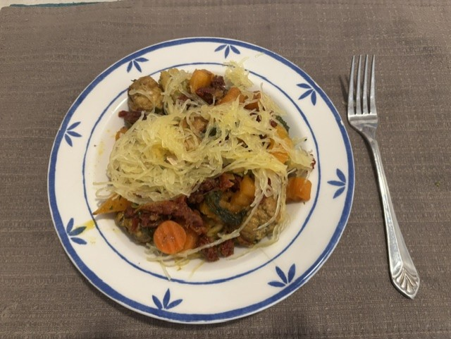 Linda's typical lunch plate — spaghetti squash with turkey meatballs, sundried tomatoes, butternut squash, spinach and carrots on a blue-rimmed plate